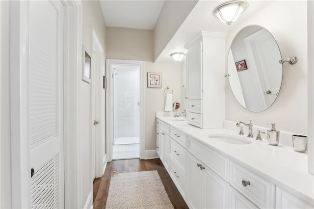 bathroom featuring walk in shower, vanity, and hardwood / wood-style flooring