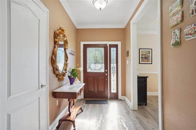 entryway with light wood-type flooring and crown molding