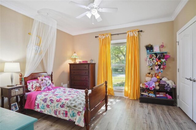 bedroom featuring ceiling fan, crown molding, and wood-type flooring