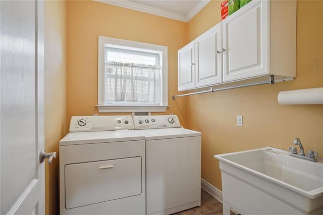 washroom with washer and dryer, hardwood / wood-style floors, sink, ornamental molding, and cabinets