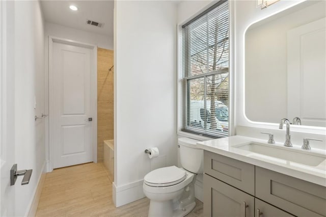 full bathroom featuring hardwood / wood-style flooring, vanity, bathtub / shower combination, and toilet