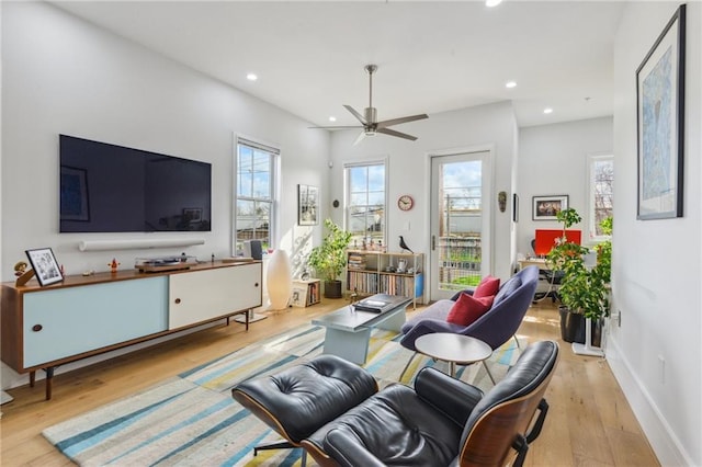 living room with light hardwood / wood-style flooring and ceiling fan