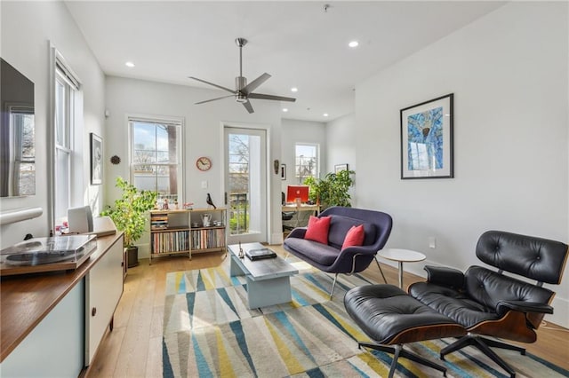 living area featuring ceiling fan and light hardwood / wood-style floors