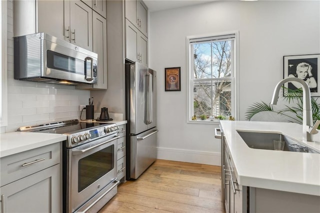 kitchen featuring decorative backsplash, sink, plenty of natural light, and stainless steel appliances