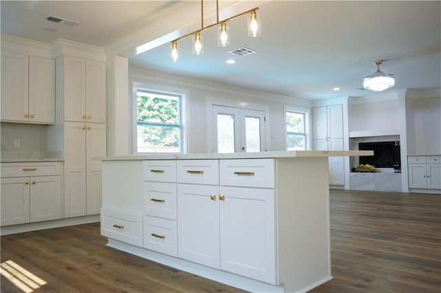 kitchen featuring a wealth of natural light, white cabinetry, and pendant lighting