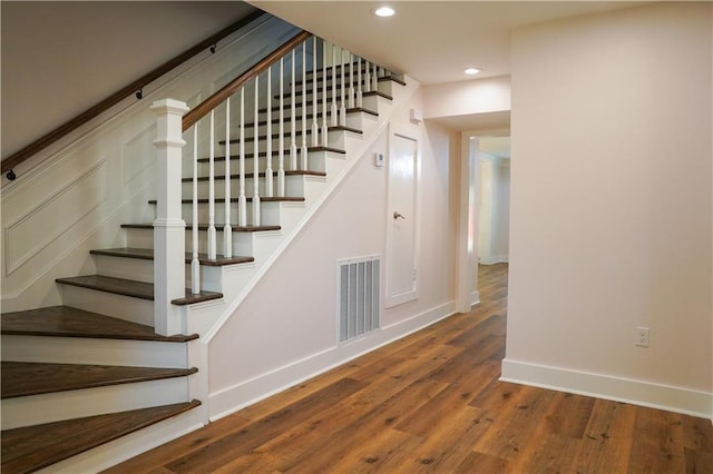 staircase with hardwood / wood-style flooring