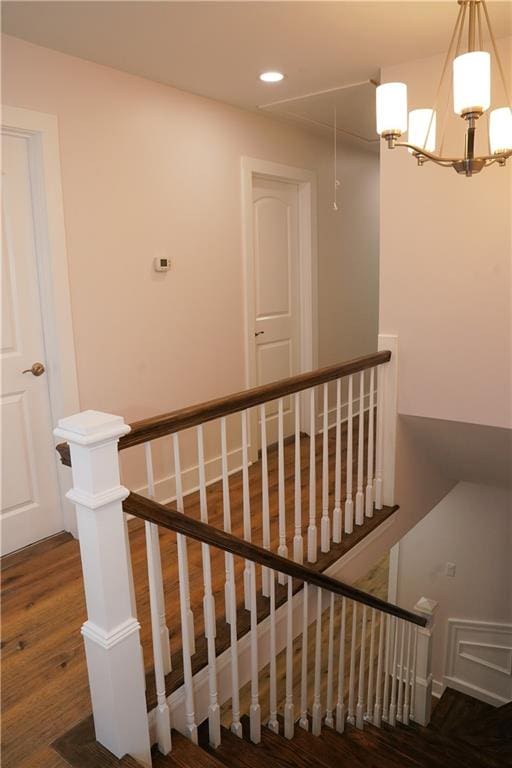 stairway with a chandelier and wood-type flooring