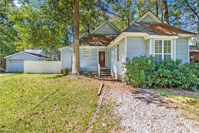 view of front of property featuring a front yard, an outbuilding, and a garage