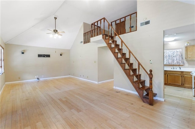 unfurnished living room with light hardwood / wood-style flooring, high vaulted ceiling, and ceiling fan