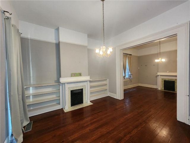 unfurnished living room featuring a notable chandelier and dark hardwood / wood-style floors