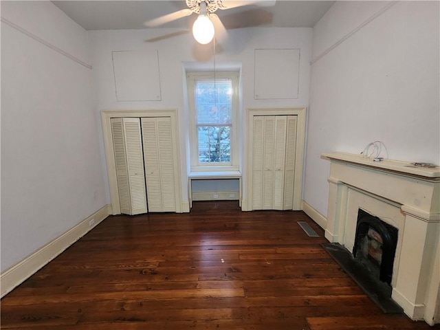 unfurnished living room with dark wood-type flooring and ceiling fan