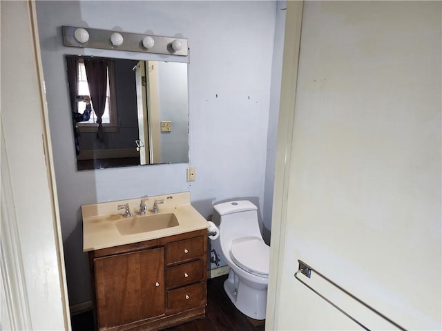 bathroom featuring toilet, hardwood / wood-style flooring, and vanity