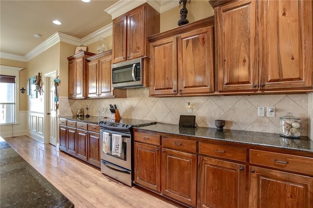 kitchen featuring dark stone countertops, stainless steel appliances, and light hardwood / wood-style flooring