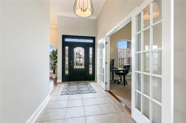 tiled foyer featuring crown molding, french doors, and a high ceiling