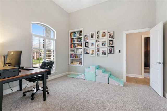 office area featuring light carpet and vaulted ceiling