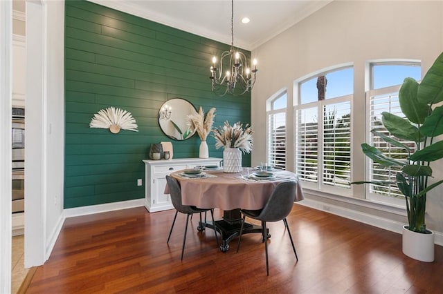 dining room featuring ornamental molding, wooden walls, dark wood-type flooring, and a wealth of natural light