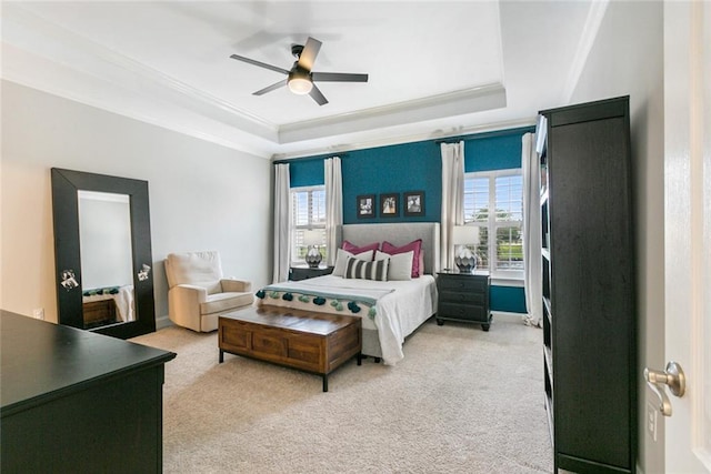 carpeted bedroom featuring a tray ceiling and ceiling fan