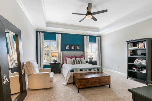 bedroom featuring crown molding, a tray ceiling, carpet, and ceiling fan