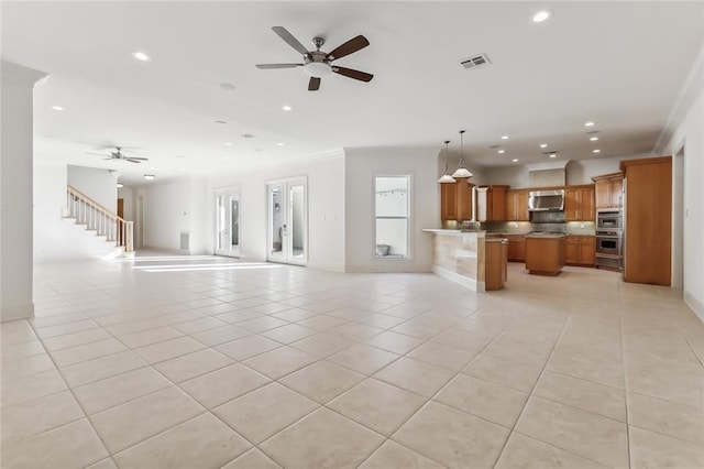 unfurnished living room with ceiling fan, ornamental molding, and light tile patterned flooring