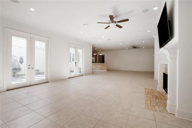 unfurnished living room featuring a wealth of natural light, french doors, and ceiling fan