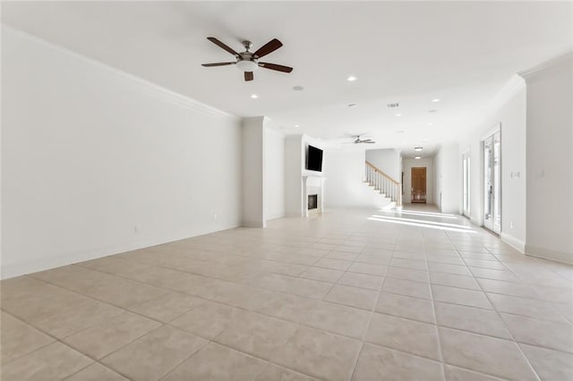 tiled empty room with ornamental molding and ceiling fan