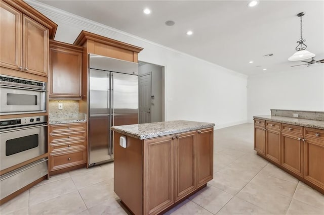 kitchen featuring crown molding, appliances with stainless steel finishes, light tile patterned flooring, and hanging light fixtures