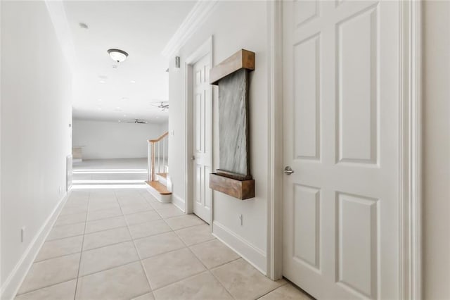 hallway with crown molding and light tile patterned flooring