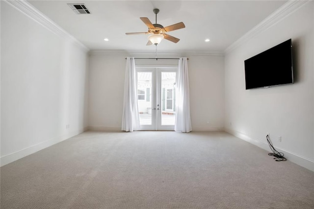 carpeted spare room with crown molding, french doors, and ceiling fan