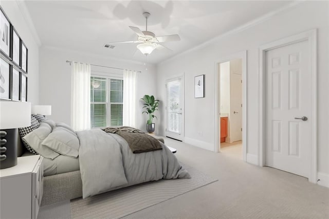 bedroom featuring ornamental molding, ensuite bathroom, light colored carpet, and ceiling fan