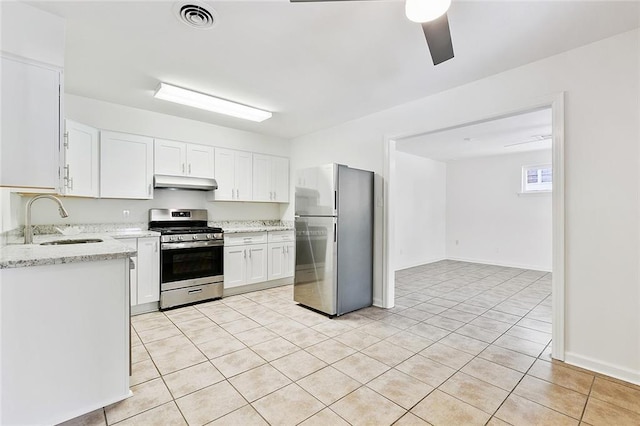 kitchen with white cabinets, stainless steel appliances, sink, light tile patterned flooring, and light stone counters