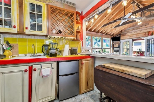 bar featuring sink, stainless steel fridge, vaulted ceiling, and ceiling fan