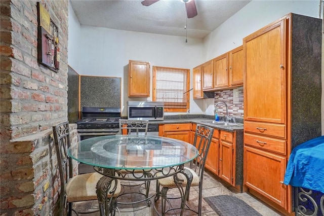 kitchen featuring sink, decorative backsplash, stainless steel appliances, and ceiling fan