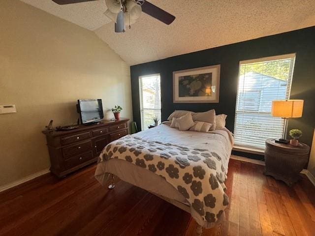 bedroom featuring ceiling fan, dark hardwood / wood-style flooring, vaulted ceiling, and a textured ceiling