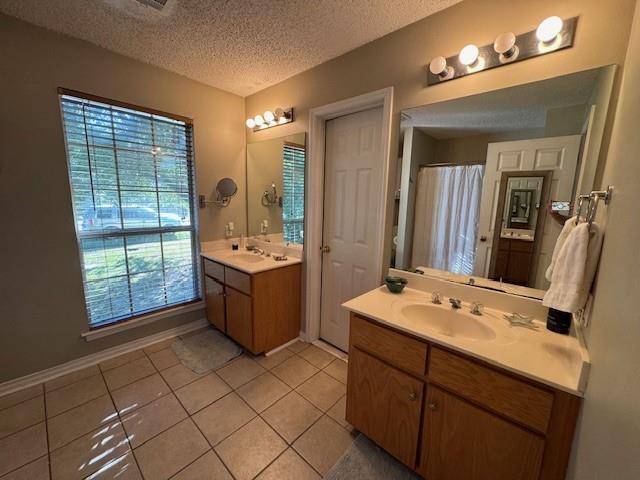 bathroom featuring plenty of natural light, tile patterned floors, and a textured ceiling