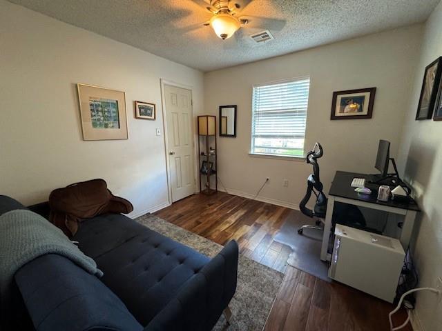 office featuring ceiling fan, dark wood-type flooring, and a textured ceiling