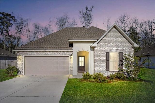 view of front of property featuring a yard and a garage