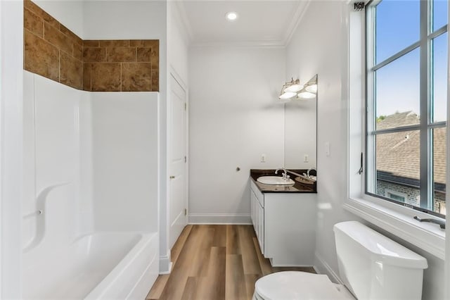 full bathroom featuring toilet, vanity, crown molding, hardwood / wood-style flooring, and tub / shower combination