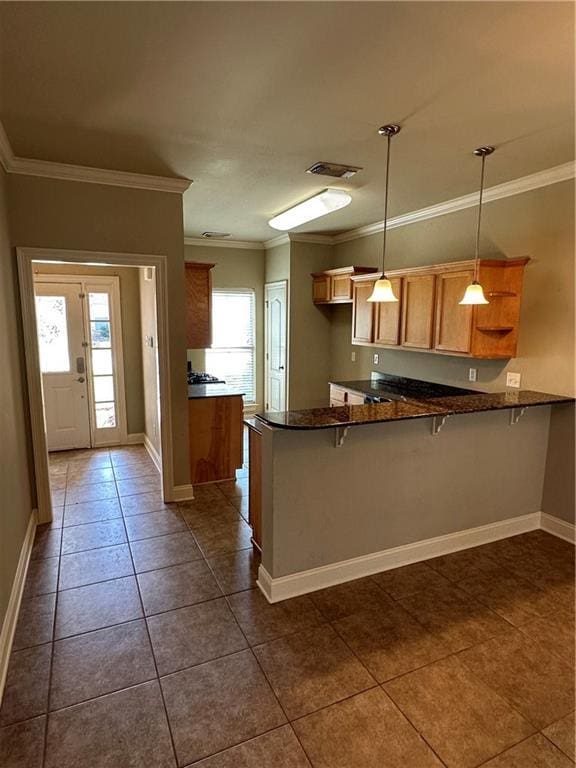 kitchen with dark tile patterned flooring, ornamental molding, open shelves, a peninsula, and baseboards