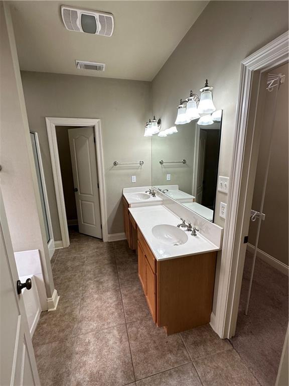 bathroom featuring a sink, visible vents, and tile patterned flooring