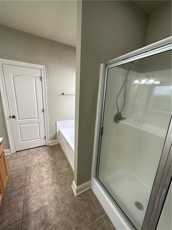 full bath featuring a bath, a shower stall, tile patterned floors, and vanity