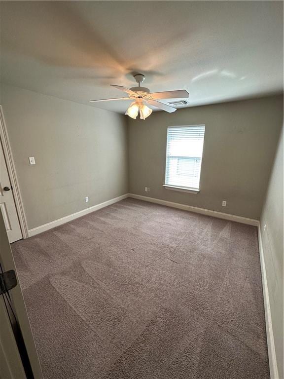 carpeted empty room with visible vents, a ceiling fan, and baseboards