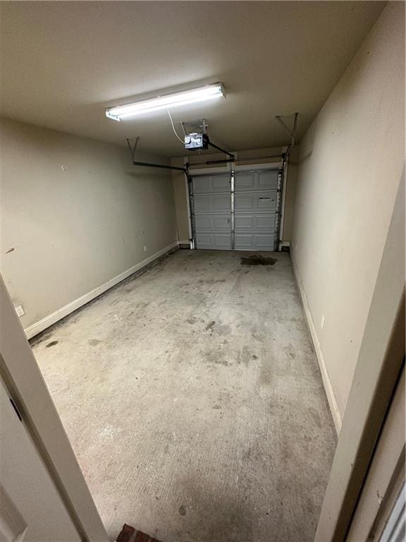 garage featuring a garage door opener and baseboards