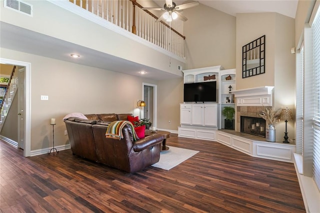 living room with a tiled fireplace, high vaulted ceiling, dark hardwood / wood-style flooring, and ceiling fan