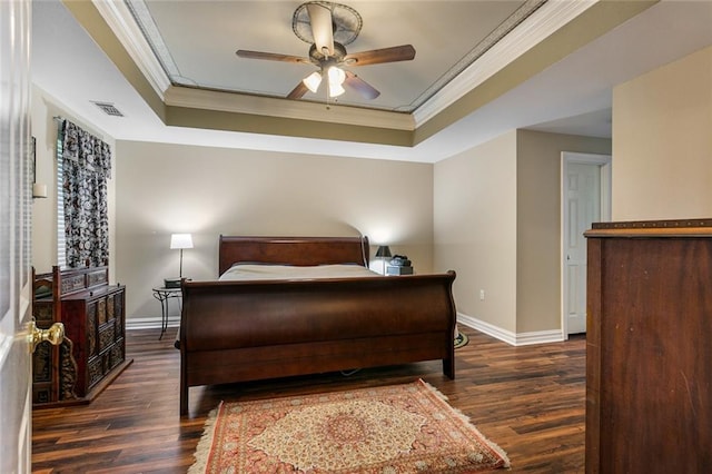 bedroom with dark wood-type flooring, ceiling fan, crown molding, and a raised ceiling