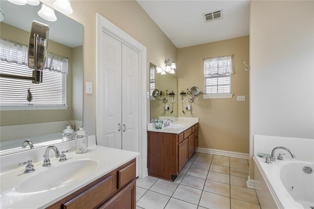 bathroom with vanity, tile patterned floors, and a washtub