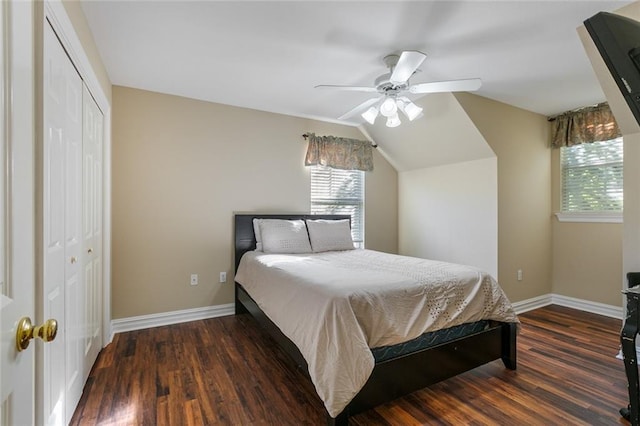 bedroom with dark wood-type flooring, vaulted ceiling, a closet, and ceiling fan