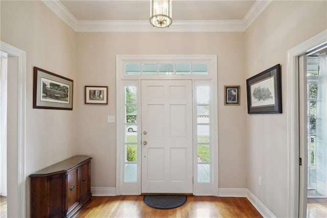 foyer featuring plenty of natural light, light wood-type flooring, and crown molding