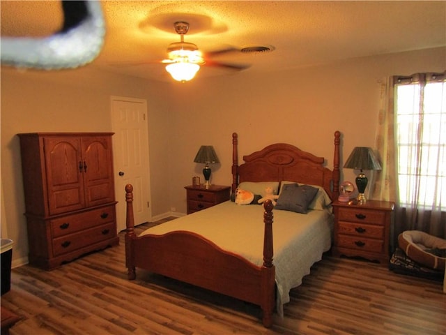 bedroom featuring a textured ceiling, dark hardwood / wood-style floors, and ceiling fan