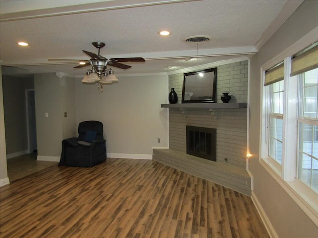 unfurnished living room with crown molding, wood-type flooring, a brick fireplace, and ceiling fan