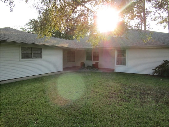 back of property featuring a patio area and a lawn